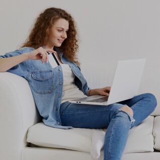 Segurança e transparência para o seu negócio Imagem de uma pessoa usando seu notebook e cartão de crédito.