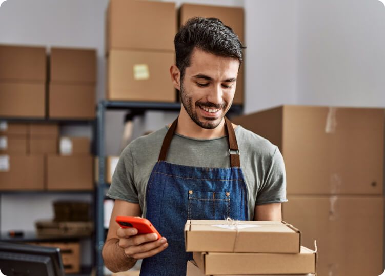 Cadastre-se para garantir as nossas soluções e tenha tudo em um só lugar. Homem sorrindo segurando pacote/encomenda